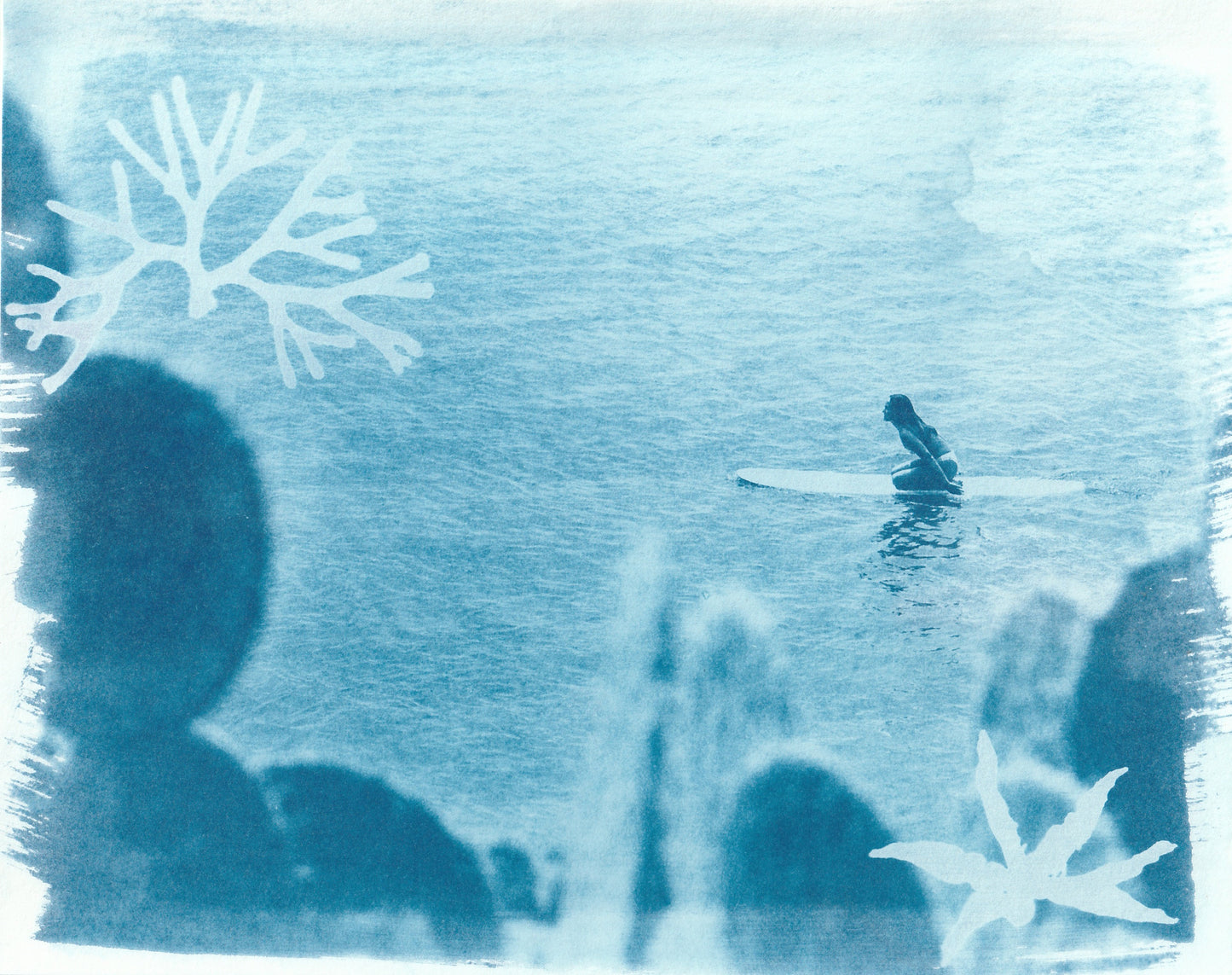 Cyanotype surf art print inspired by Costa Rica featuring a lone surfer in blue ocean tones with botanical overlays
